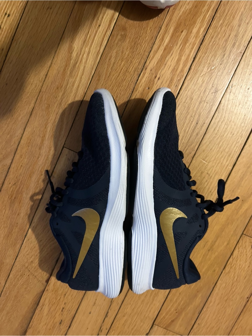 Nike Women's Black Athletic Shoe with Gold Swoosh